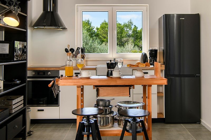 Gemütliche Küche mit Holzmöbeln und modernen Geräten.