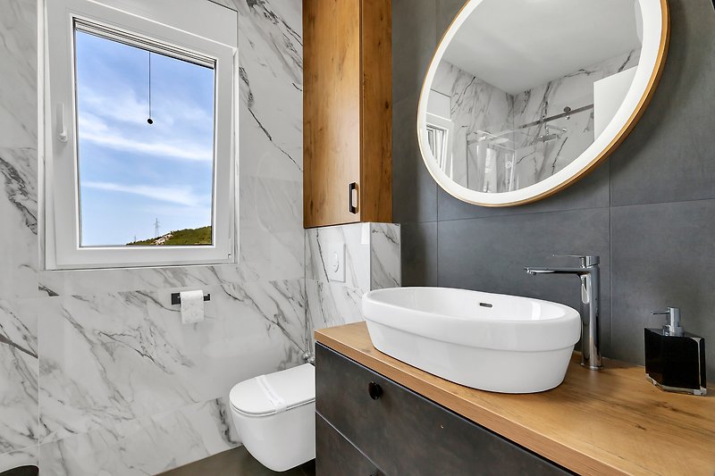 Ein stilvolles Badezimmer mit lila Armaturen und Keramikwaschbecken.