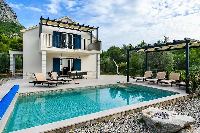 Einladender Pool mit Sonnenliegen und stilvoller Außenmöblierung.