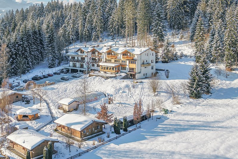 Berglandschaft mit Schnee, Haus und Fenstern - Winterurlaub in den Bergen.