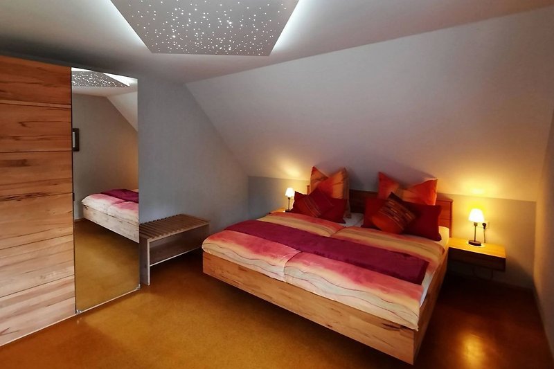 Stilvolles Schlafzimmer mit gemütlichem Bett und Holzmöbeln.