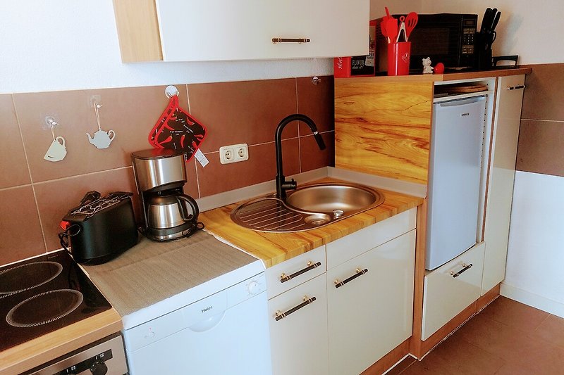 Moderne Küche mit Holzschrank, Arbeitsplatte, Spüle und Herd.