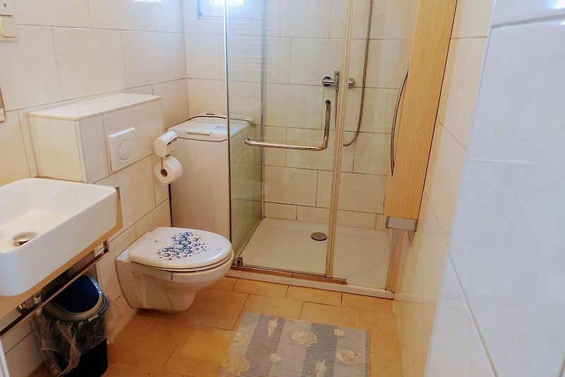 Badezimmer mit lila Akzenten, Dusche, Fenster und Handtuch.