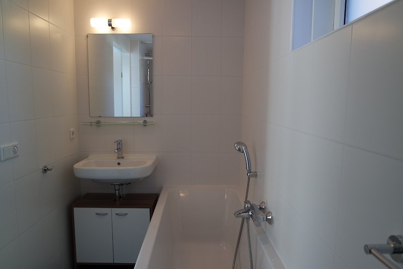Badezimmer mit lila Akzenten, Glasdusche und Badewannenauslauf.