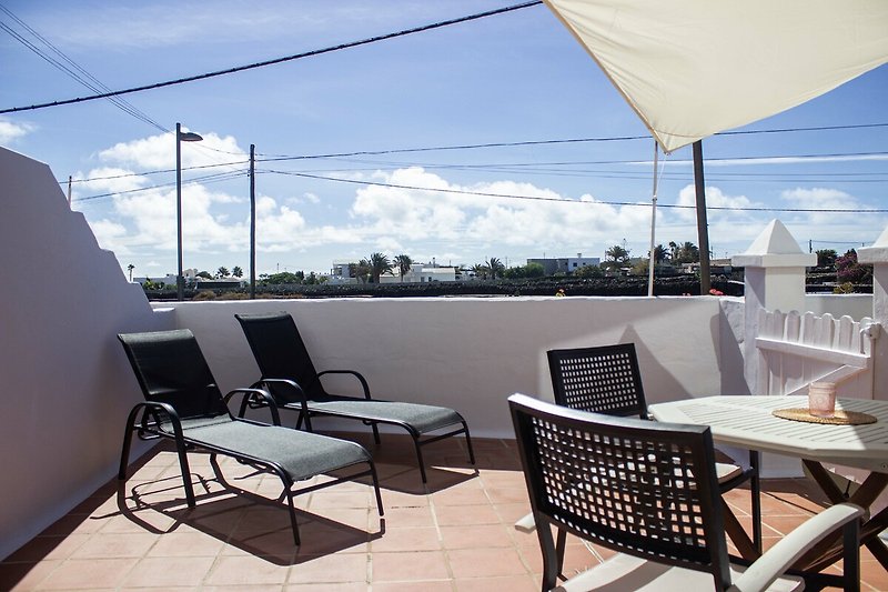Terrasse mit Sonnenliegen, sowie Tisch und Stühlen