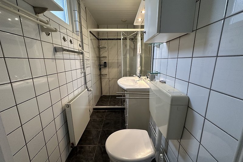 Modernes Badezimmer mit Aluminiumarmaturen und Fliesen.
