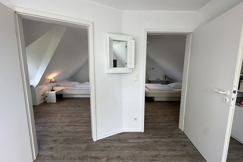 Geräumiges Schlafzimmer mit Holzbett, Bettwäsche und Sash-Fenster.