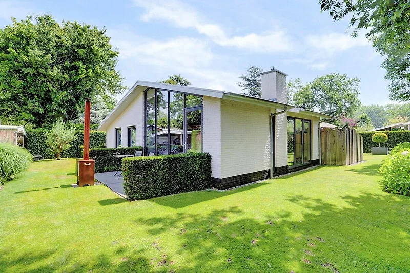 Charmante Villa mit gepflegtem Garten und einladender Veranda.