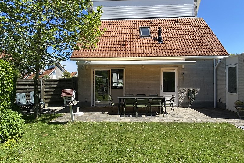 Ländliches Haus mit Veranda und gepflegtem Garten.