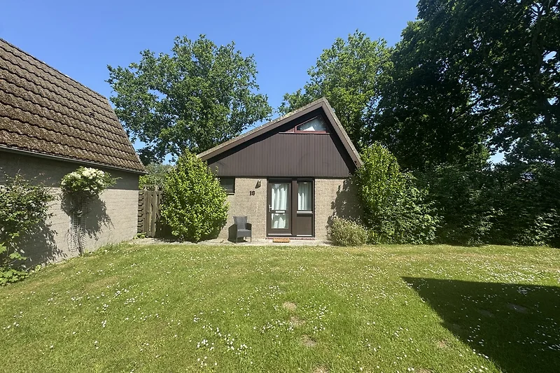 Haus mit Garten und grüner Rasenfläche für erholsame Tage.