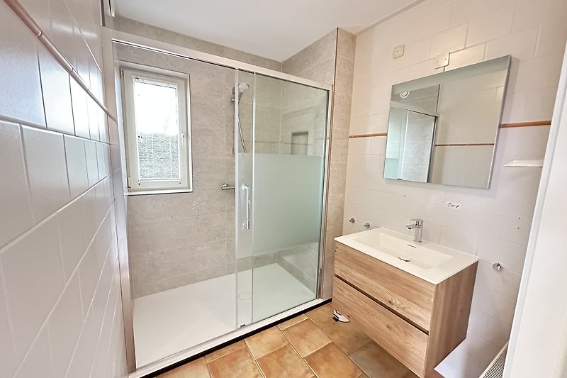 Modernes Badezimmer mit Dusche, Spiegel, Waschbecken und Holzdetails.