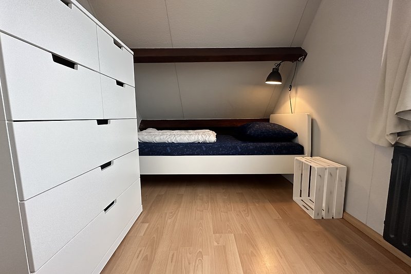 Gemütliches Schlafzimmer mit Holzmöbeln und bequemem Bett.