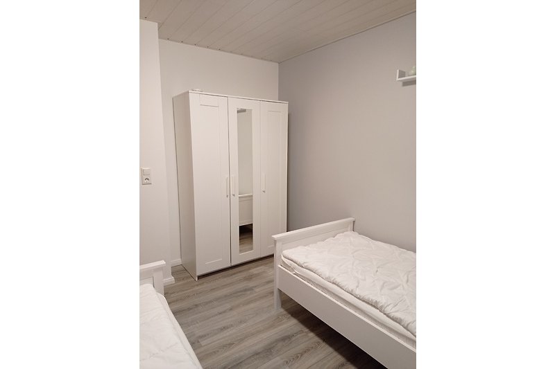 Komfortables Schlafzimmer mit Holzboden und stilvollem Interieur.
