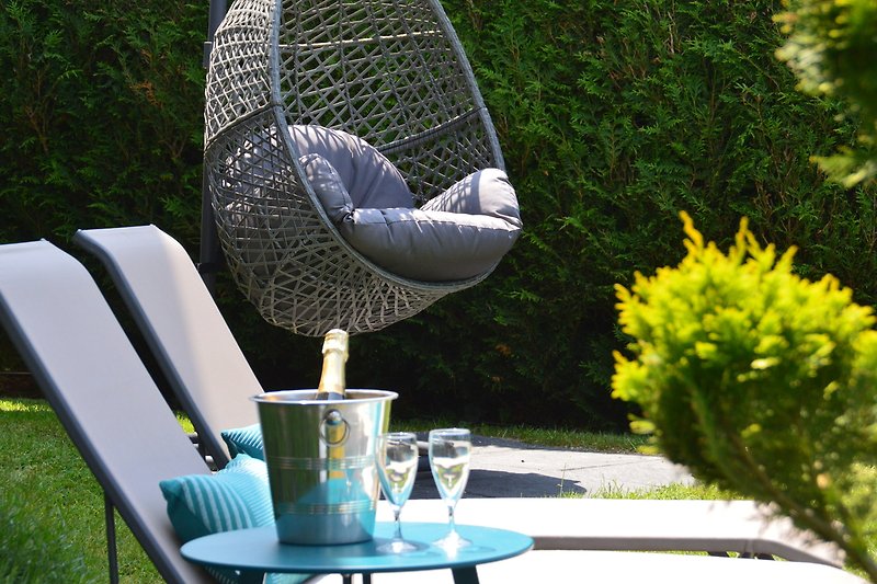 Gartenidylle mit grünen Pflanzen, Tisch und Stühlen - Naturverbundenheit pur!