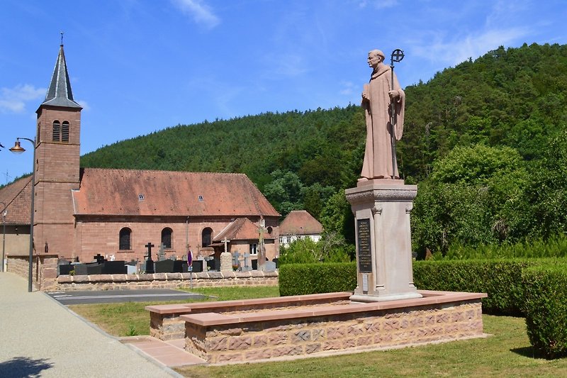 Historische Kapelle mit Turm und Skulptur.