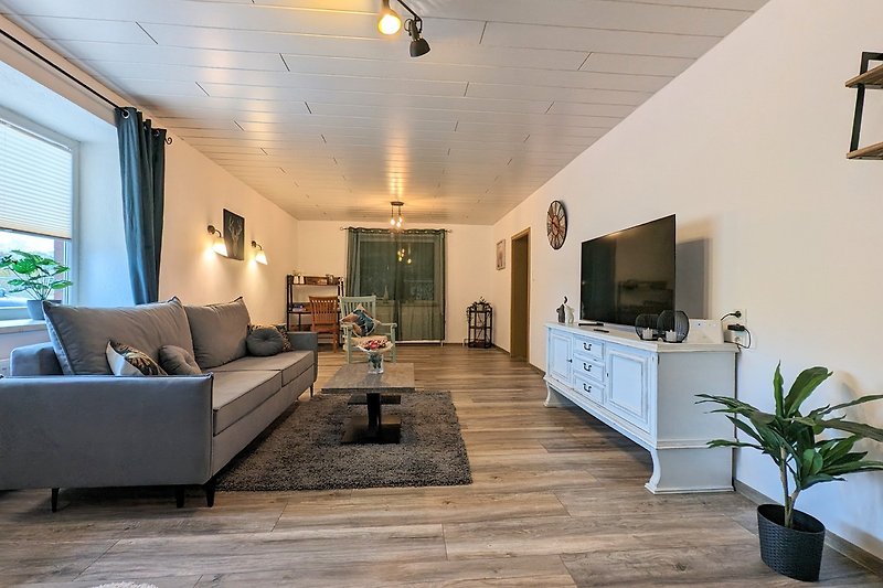 Gemütliches Wohnzimmer mit stilvoller Dekoration und Holzmöbeln.
