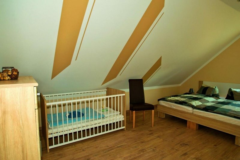 Schlafzimmer mit Doppelbett und Babybett