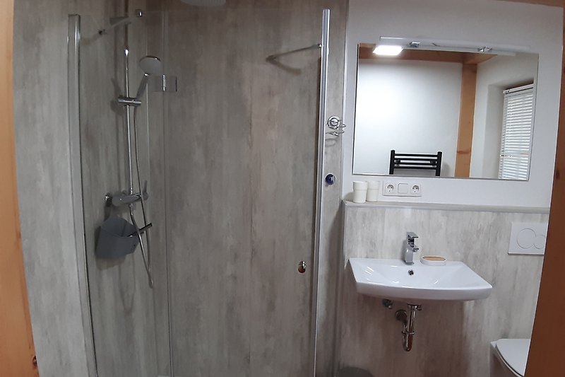 Schönes Badezimmer mit Spiegel, Waschbecken und Dusche.