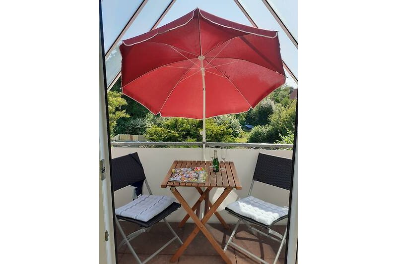 Sommerliches Ambiente mit Sonnenschirm und Balkonmöbeln