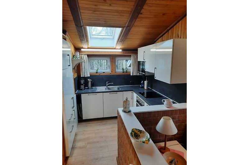 Moderne Küche mit Holzoberflächen, Granit-Arbeitsplatte und stilvollen Armaturen.