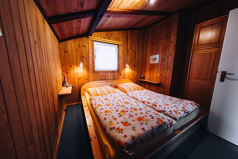 Komfortables Schlafzimmer mit stilvollem Holzbett und gemütlicher Beleuchtung.