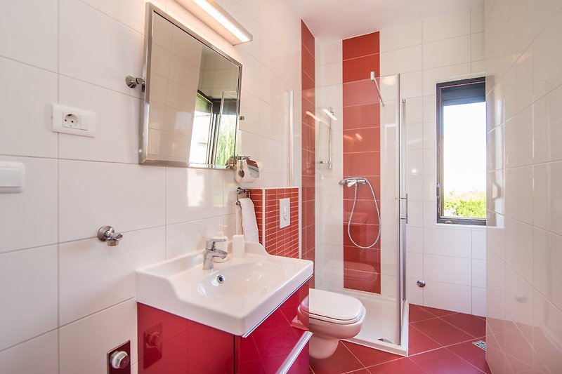 Modernes Badezimmer mit lila Akzenten, Spiegel, Waschbecken und Fenster - stilvoll gestaltet!