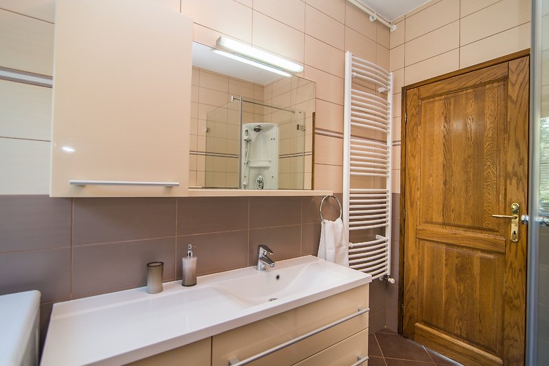Modernes Badezimmer mit Spiegel, Waschbecken, Badewanne und Tür - stilvoll gestaltet!