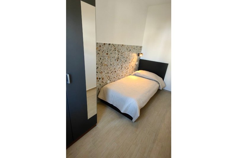 Schlafzimmer mit gemütlichem Bett, Kissen und Lampe - entspannte Atmosphäre!