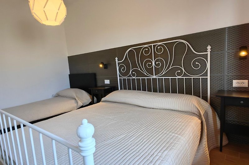 Elegantes Schlafzimmer mit stilvollem Bett, gemütlichen Kissen und eleganten Lampen. Luxuriöse Atmosphäre!