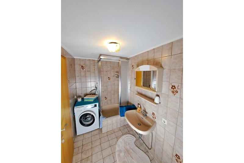 Badezimmer mit Dusche, Wasmaschine, Spiegel und Waschbecken & Toilette - Fussbodenheizung