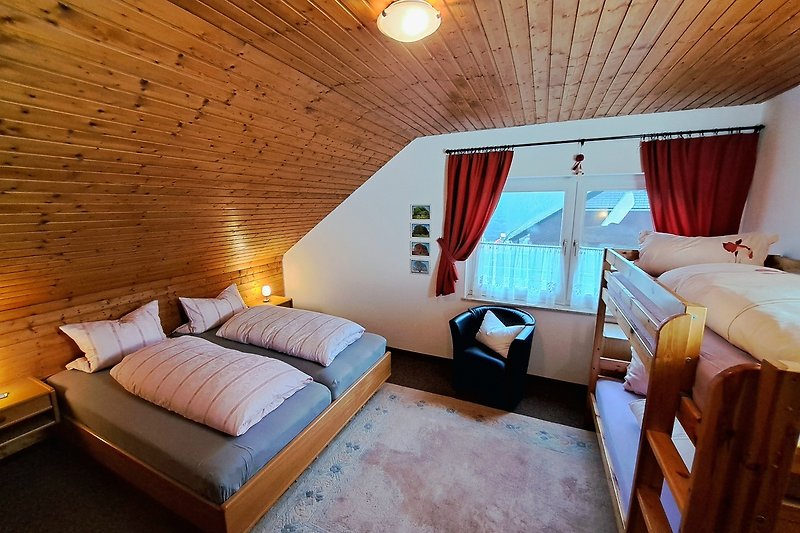 Komfortables Schlafzimmer mit Holzmöbeln, Doppelbett und Etagenbett