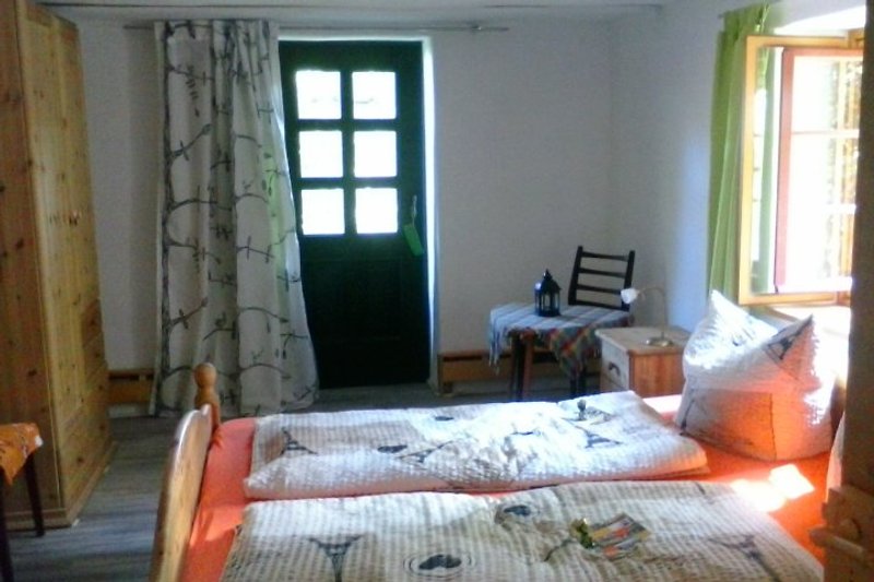 FeWo Schlafzimmer mit Blick zur Terasse (Tür) & Gartenbereich plus Kinderbett (70x140)