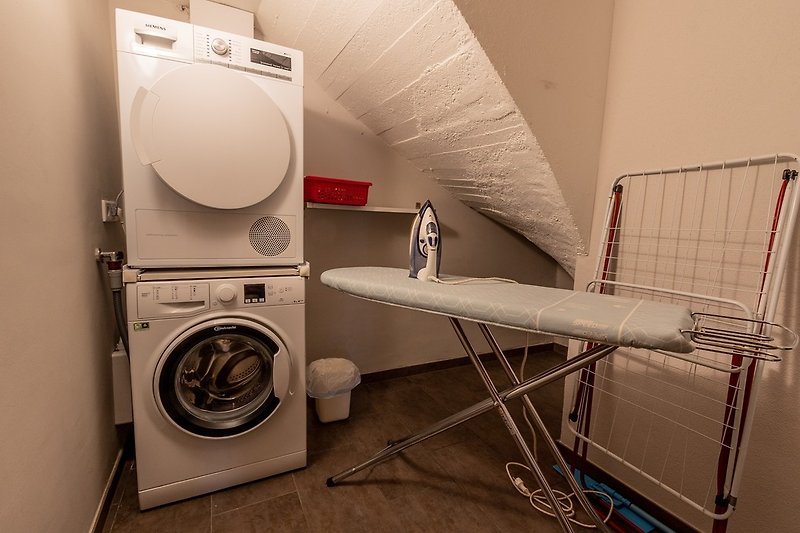 Laundry room with washing machine, dryer, ironing board and iron