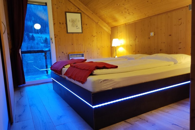 Gemütliches Schlafzimmer mit Holzbett und blauen Akzenten.