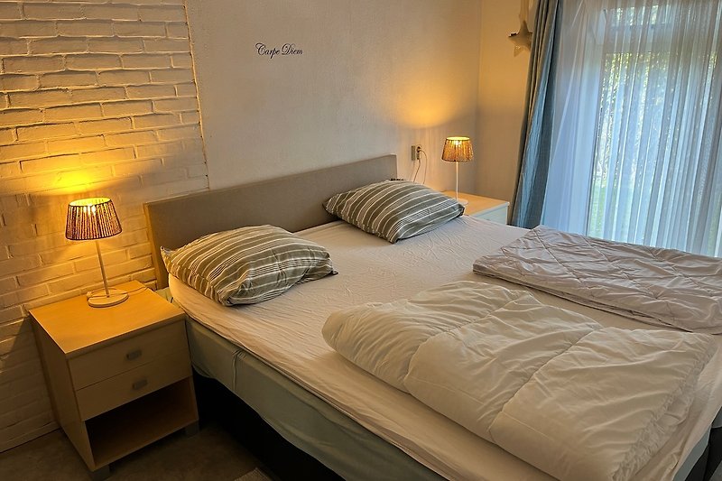 Schlafzimmer mit gemütlichem Bett und stilvoller Beleuchtung.