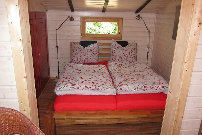 Elegantes Schlafzimmer mit Himmelbett, Holzmöbeln und Fenster.