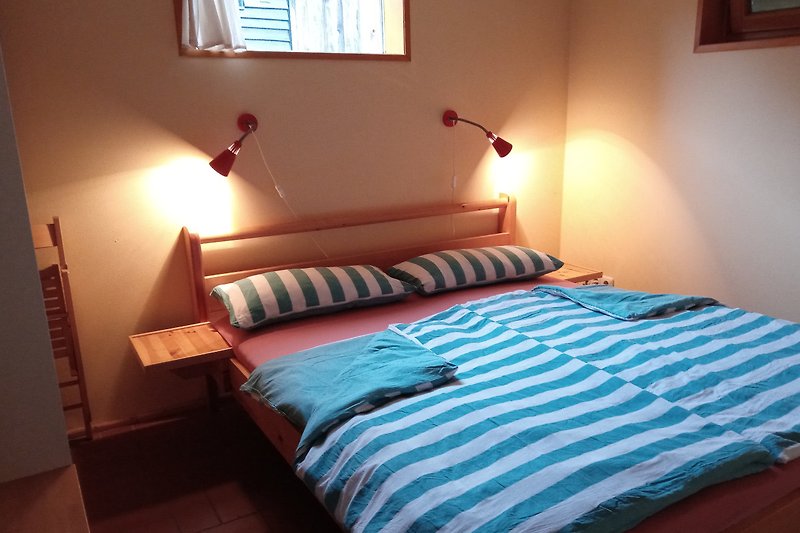 Gemütliches Schlafzimmer mit Holzbett 160x200 cm und stilvoller Inneneinrichtung.