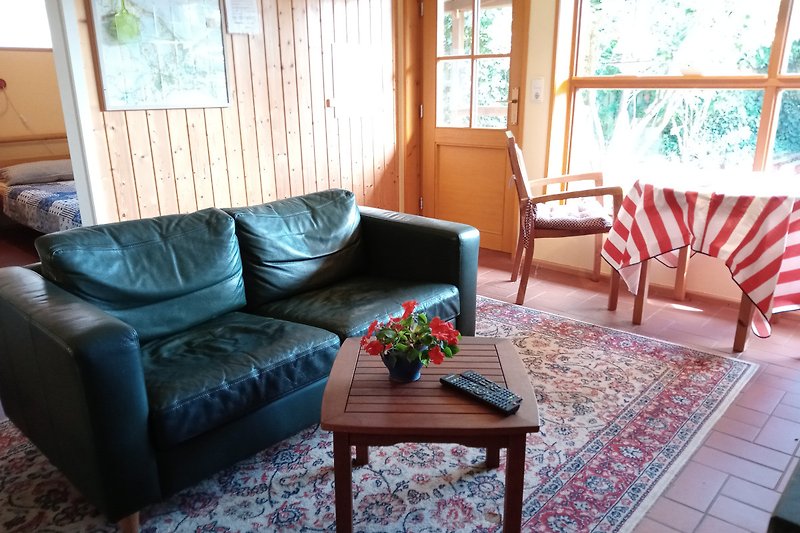 Gemütliches Wohnzimmer mit bequemer Couch und Holzmöbeln im kleinen separaten FH.