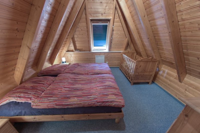 Elternschlafzimmer mit massivem Kinderbett im OG
