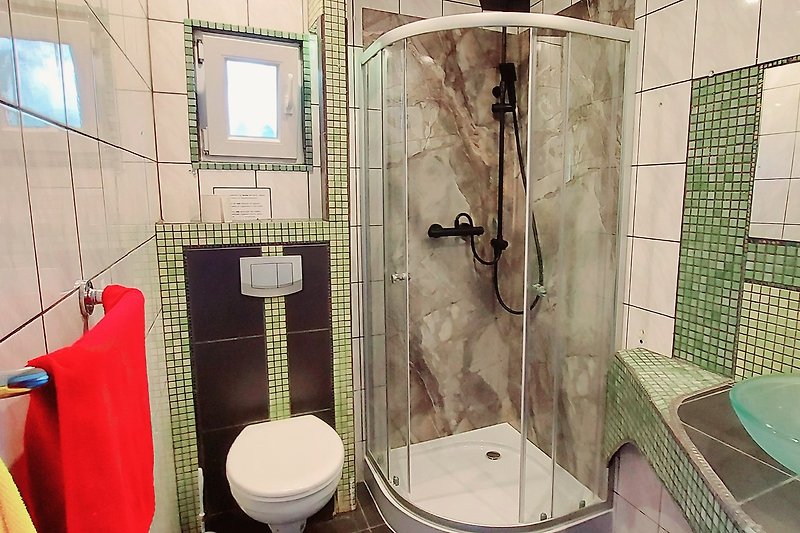 Schönes Badezimmer mit lila Dusche und Glasduschtür.