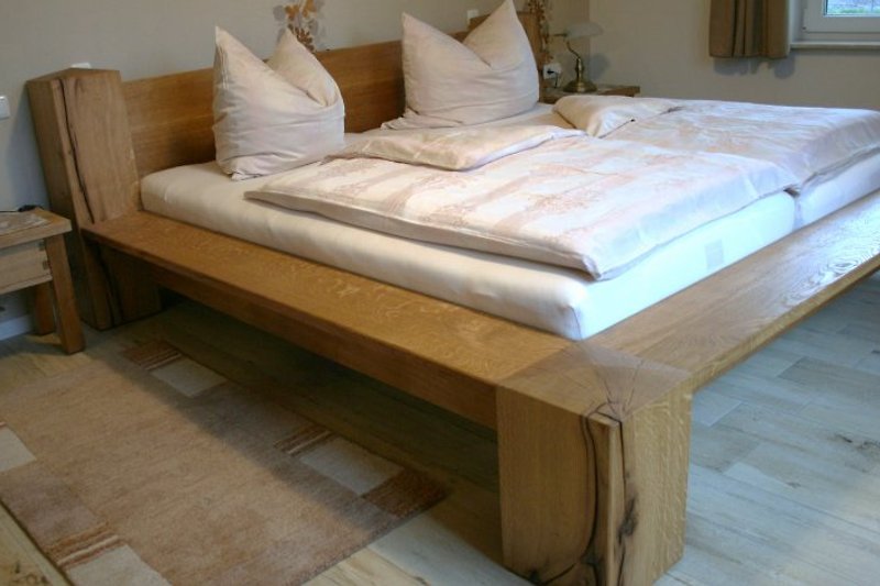 Das Schlafzimmer mit einem massiven Bett aus norddeutscher Wildeiche 
