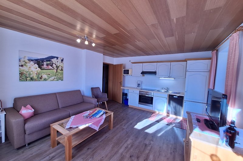 Gemütliches Wohnzimmer mit lila Couch, Holztisch und purpurfarbenem Interieur.