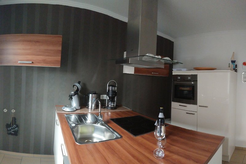 Exclusiv ausgestattete Hochglanzküche mit Kochinsel, zusätzlich zur Designerkaffeemaschine eine Senseo Maschine und ein Wasserkocher.