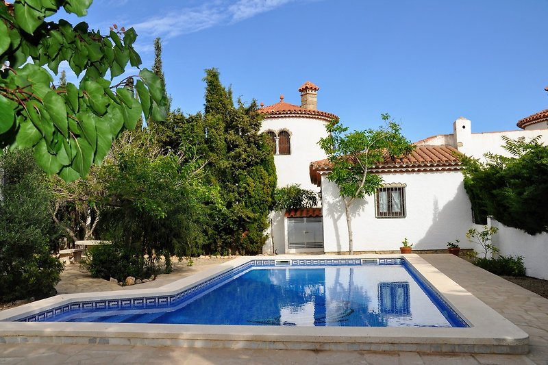 Villa mit Pool, Palmen und Balkon in ruhiger Wohngegend.