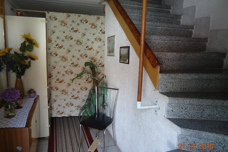 Holzinterieur mit Blumen und Pflanzen. Gemütliche Treppe.