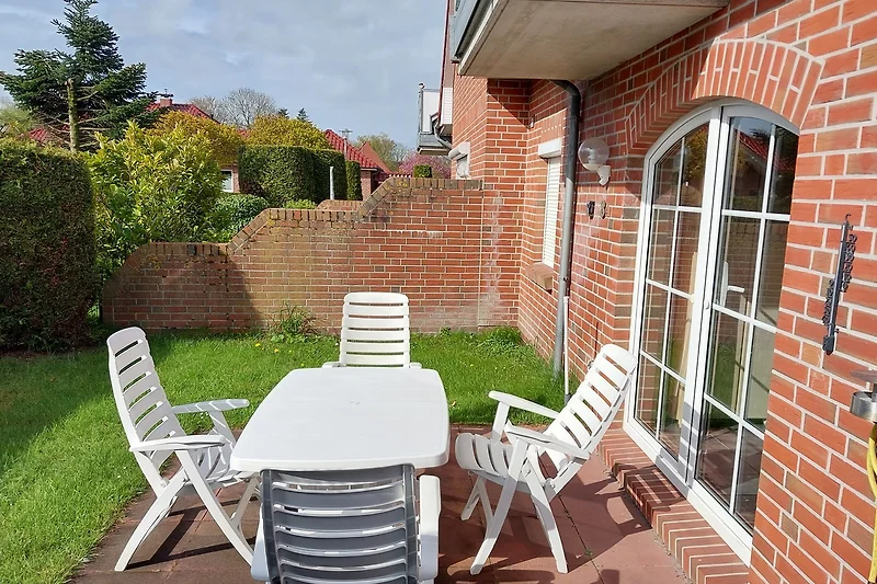 Gemütliche Terrasse mit Möbeln und Pflanzen.