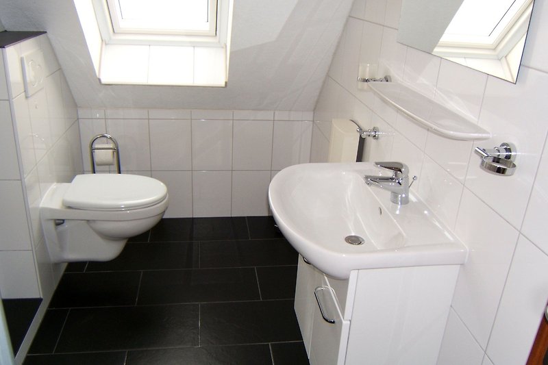 Schönes Badezimmer mit lila Waschbecken, Spiegel und Armatur.
