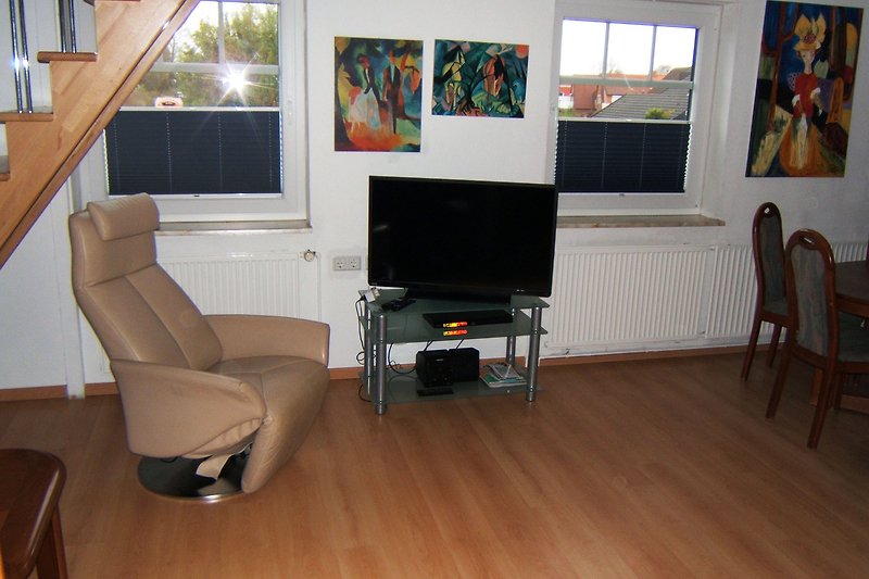 Gemütliches Wohnzimmer mit stilvoller Einrichtung und großem Fernseher.