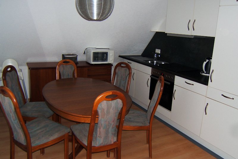 Gemütliche Küche mit Holzmöbeln und modernen Geräten.