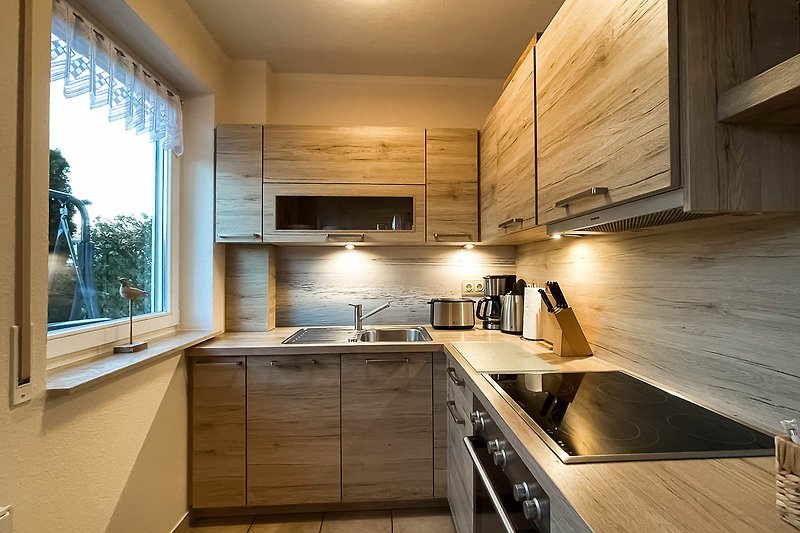 Moderne Küche mit Holzakzenten und Edelstahlgeräten.